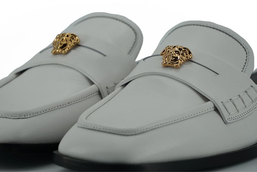 Sandalias planas elegantes de cuero blanco de Versace